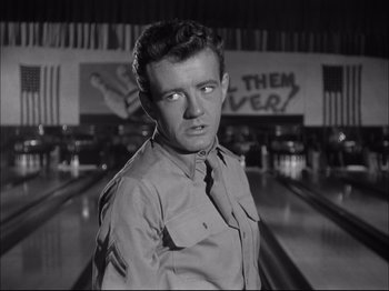 Movie still from “Since You Went Away” (1944), directed by John Cromwell – A man standing in front of a bowling alley; Close Up shot, Low angle