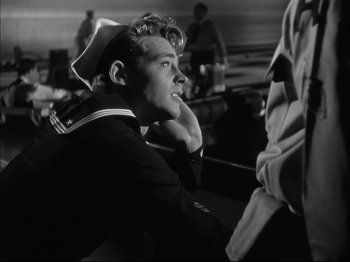 Movie still from “Since You Went Away” (1944), directed by John Cromwell – Black and white photograph of a man in a sailor's uniform; Medium shot, Low angle