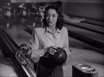 Movie still from “Since You Went Away” (1944), directed by John Cromwell – A black and white photo of a woman holding a bowling ball; Close Up shot, Low angle
