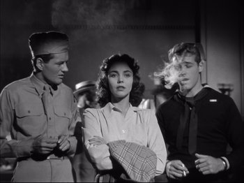 Movie still from “Since You Went Away” (1944), directed by John Cromwell – A group of men standing next to a woman; Medium shot, Low angle