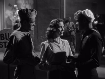 Movie still from “Since You Went Away” (1944), directed by John Cromwell – A group of people standing next to each other on a street; Medium shot, Low angle