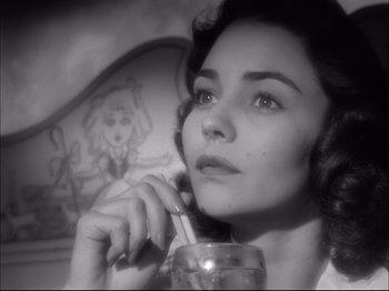 Movie still from “Since You Went Away” (1944), directed by John Cromwell – A black - and - white photo of a woman holding a drink; Close Up shot, Low angle