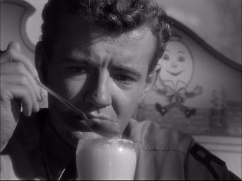 Movie still from “Since You Went Away” (1944), directed by John Cromwell – A black and white photo of a man drinking a glass of milk; Close Up shot, High angle