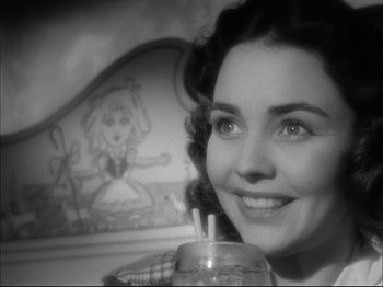 Movie still from “Since You Went Away” (1944), directed by John Cromwell – A black - and - white photo of a woman holding a drink; Close Up shot, Over the shoulder angle