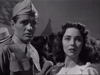 Movie still from “Since You Went Away” (1944), directed by John Cromwell – A man and a woman standing next to each other in a black and white photo; Close Up shot, Low angle