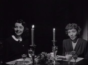 Movie still from “Since You Went Away” (1944), directed by John Cromwell – Two women sitting at a dinner table with lit candles; Medium shot, Low angle