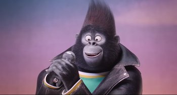 Movie still from “Sing” (2016), directed by Christophe Lourdelet – A gorilla is holding a microphone in his hand; Close Up shot, Low angle
