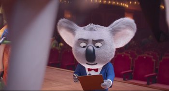 Movie still from “Sing” (2016), directed by Christophe Lourdelet – A cartoon koala wearing a blue jacket and a red bow tie; Medium shot, Over the shoulder angle