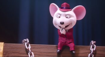 Movie still from “Sing” (2016), directed by Christophe Lourdelet – A toy mouse sitting on top of a wooden table next to a chain; Close Up shot, High angle