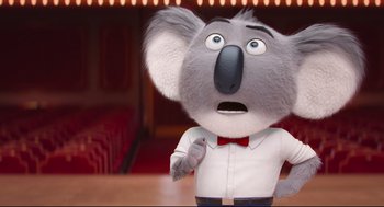 Movie still from “Sing” (2016), directed by Christophe Lourdelet – A toy koala wearing a white shirt and a red bow tie; Close Up shot, Low angle