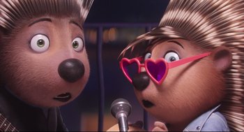 Movie still from “Sing” (2016), directed by Christophe Lourdelet – A couple of dogs that are next to a microphone; Close Up shot, Over the shoulder angle
