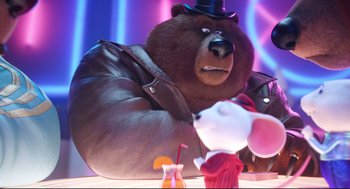 Movie still from “Sing” (2016), directed by Christophe Lourdelet – A brown bear wearing a top hat next to a white mouse; Medium shot, Over the shoulder angle