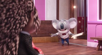 Movie still from “Sing” (2016), directed by Christophe Lourdelet – A cartoon koala is standing on a wooden floor; Medium shot, Over the shoulder angle