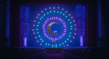 Movie still from “Sing” (2016), directed by Christophe Lourdelet – A stage lit up with lights and a large moon; Extreme Wide shot, Low angle