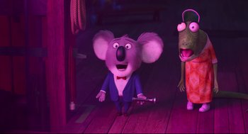 Movie still from “Sing” (2016), directed by Christophe Lourdelet – A koala is standing on the floor next to a rat; Medium shot, Over the shoulder angle
