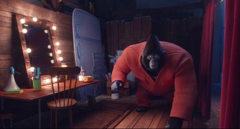 Movie still from “Sing” (2016), directed by Christophe Lourdelet – An animated gorilla in a red suit is standing in a room; Wide shot, Low angle