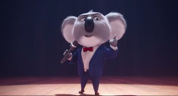 Movie still from “Sing” (2016), directed by Christophe Lourdelet – A cartoon koala is holding a microphone in his hand; Medium shot, Low angle