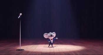 Movie still from “Sing” (2016), directed by Christophe Lourdelet – A mouse is dancing on a stage in front of a spotlight; Wide shot, Low angle