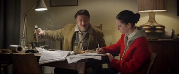 Movie still from “Sing Street” (2016), directed by John Carney – A man and a woman sitting at a dinner table; Medium shot, Over the shoulder angle