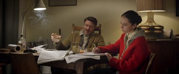 Movie still from “Sing Street” (2016), directed by John Carney – A man and a woman sitting at a dinner table; Medium shot, Over the shoulder angle