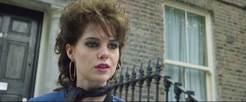 Movie still from “Sing Street” (2016), directed by John Carney – A person wearing a neck scarf; Close Up shot, Over the shoulder angle