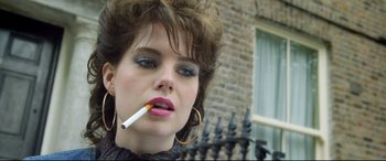 Movie still from “Sing Street” (2016), directed by John Carney – A person holding a cigarette in her mouth; Close Up shot, Low angle
