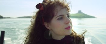 Movie still from “Sing Street” (2016), directed by John Carney – A person with long curly hair; Close Up shot, Low angle