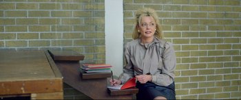 Movie still from “Sing Street” (2016), directed by John Carney – A woman sitting at a table writing on a piece of paper; Medium shot, Over the shoulder angle