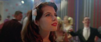 Movie still from “Sing Street” (2016), directed by John Carney – A beautiful young lady wearing a bow in her hair; Close Up shot, Low angle