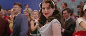 Movie still from “Sing Street” (2016), directed by John Carney – A woman in a white dress with a white bow in her hair; Close Up shot, Over the shoulder angle