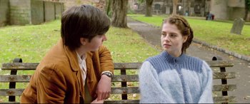 Movie still from “Sing Street” (2016), directed by John Carney – Two people sitting on a bench in a park; Medium shot, Over the shoulder angle