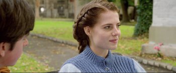 Movie still from “Sing Street” (2016), directed by John Carney – A woman with a braid in her hair; Close Up shot, Over the shoulder angle