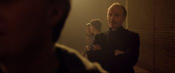 Movie still from “Sing Street” (2016), directed by John Carney – A group of people standing in a dimly - lit room; Close Up shot, Over the shoulder angle