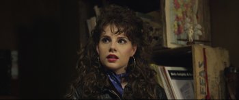 Movie still from “Sing Street” (2016), directed by John Carney – A person with curly hair wearing a neck scarf; Close Up shot, Over the shoulder angle