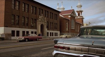 Movie still from “Sister Act” (1992), directed by Emile Ardolino – An old car parked on the side of the street; Extreme Wide shot, Low angle
