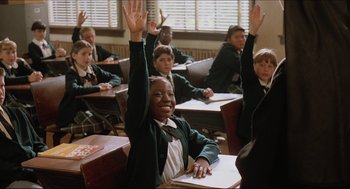 Movie still from “Sister Act” (1992), directed by Emile Ardolino – A group of children sitting at desks raising their hands; Medium shot, High angle