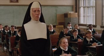 Movie still from “Sister Act” (1992), directed by Emile Ardolino – A woman in a nun's outfit standing in front of a classroom; Medium shot, Low angle