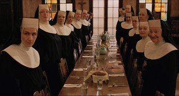 Movie still from “Sister Act” (1992), directed by Emile Ardolino – A group of nuns sitting at a long dinner table; Wide shot, High angle