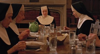 Movie still from “Sister Act” (1992), directed by Emile Ardolino – A group of people sitting at a table with plates of food; Medium shot, High angle
