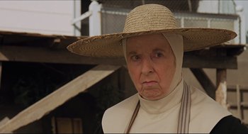 Movie still from “Sister Act” (1992), directed by Emile Ardolino – An older woman wearing a straw hat and a white apron; Close Up shot, Low angle