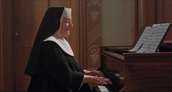 Movie still from “Sister Act” (1992), directed by Emile Ardolino – An old woman in a nun's outfit playing the piano; Medium shot, High angle