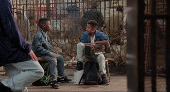 Movie still from “Sister Act” (1992), directed by Emile Ardolino – Two young men sitting on a bench in a park; Wide shot, High angle