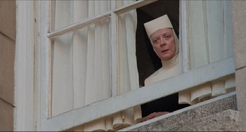 Movie still from “Sister Act” (1992), directed by Emile Ardolino – An old woman wearing a white outfit looking out of a window; Medium shot, Low angle