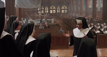 Movie still from “Sister Act” (1992), directed by Emile Ardolino – Two women in black and white uniforms in a church; Wide shot, Low angle