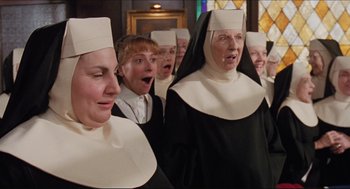 Movie still from “Sister Act” (1992), directed by Emile Ardolino – A group of people dressed as nuns singing together; Medium shot, Low angle
