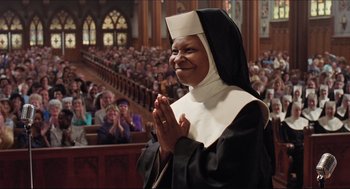 Movie still from “Sister Act” (1992), directed by Emile Ardolino – A woman in a nun's outfit clapping in front of an audience; Medium shot, Low angle