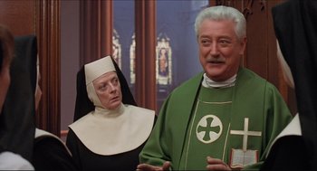 Movie still from “Sister Act” (1992), directed by Emile Ardolino – A priest and a nun are standing next to each other; Medium shot, Low angle