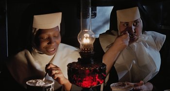 Movie still from “Sister Act” (1992), directed by Emile Ardolino – Two women dressed as nuns are lighting a lamp; Medium shot, High angle