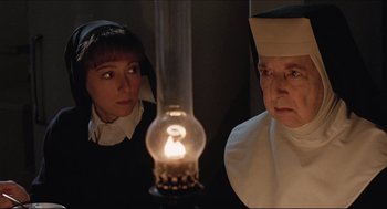 Movie still from “Sister Act” (1992), directed by Emile Ardolino – A woman and a man standing in front of an oil lamp; Close Up shot, Low angle