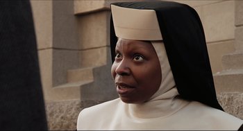 Movie still from “Sister Act” (1992), directed by Emile Ardolino – A woman in a nun's outfit looking into the distance; Close Up shot, Low angle